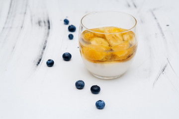 Colorful fruit jelly in a glass on a white background with blueberries