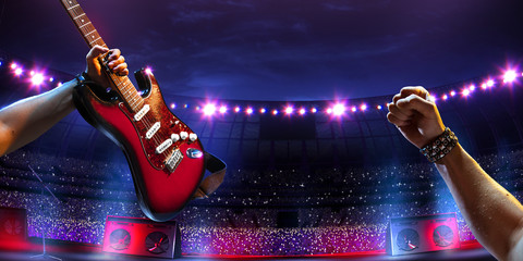 Rock star on the main stage big music festival. Aroun full stadium of spectators. fans are holding...