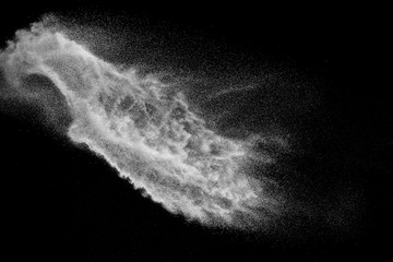 Bizarre forms of white powder explosion cloud against black background.White dust particles splash.