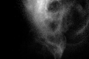 Bizarre forms of white powder explosion cloud against black background.White dust particles splash.