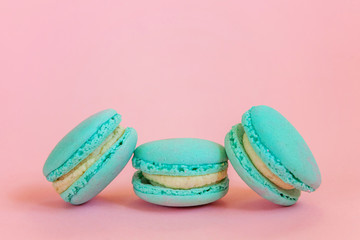 Sweet almond colorful unicorn blue macaron or macaroon dessert cake isolated on trendy pink pastel background. French sweet cookie. Minimal food bakery concept. Copy space