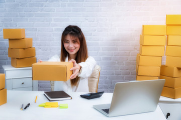 Young business entrepreneur owner working at home about online delivery business with packing box. online shopping SME entrepreneur or freelance working concept.