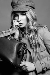 High fashion portrait of stylish blond woman in total beige look with leather bag and animal  print...