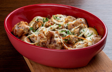 Rabbit baked in sour cream with onion in ceramic bowl