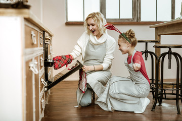 Beaming cheerful mother gently touching her daughter