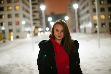 Brunette girl posing at the night winter street