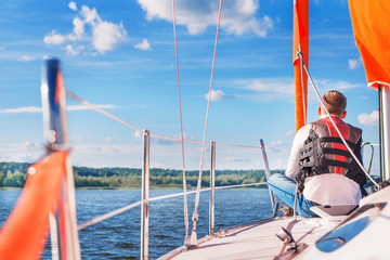 Naklejka premium young man on a boat in a life jacket