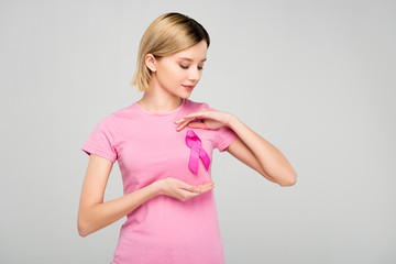 cropped view of beautiful blonde woman posing in pink t-shirt with breast cancer awareness ribbon,...