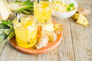 Healthy and immunity diet drink. Ginger and pineapple cold tea, infused water, Wooden background copy space