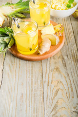 Healthy and immunity diet drink. Ginger and pineapple cold tea, infused water, Wooden background copy space