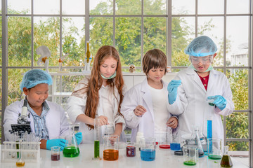 Caucasian and Asian students having chemistry experiments in science laboratory