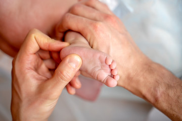 Photo from above of kid&rsquo;s feet and hands of masseur.