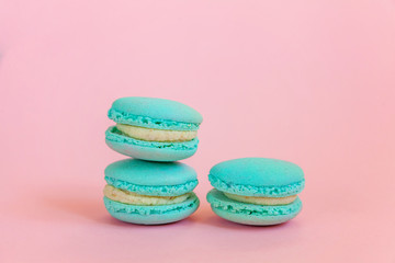 Sweet almond colorful unicorn blue macaron or macaroon dessert cake isolated on trendy pink pastel background. French sweet cookie. Minimal food bakery concept. Copy space