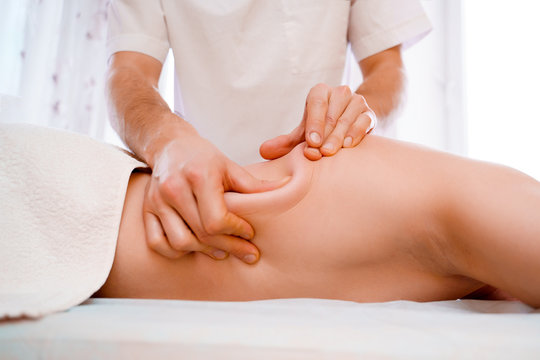 Photo of hands of massage therapist making massage to man.