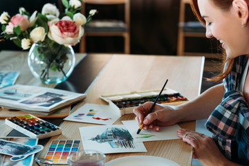 Watercolor painting. Artist at work. Smiling female painter doing color mix brushstrokes. Sketches...