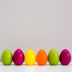 Easter background - close up of colorful painted Easter eggs and copy space over wall