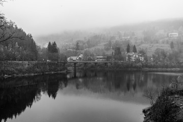 Fototapeta na wymiar View of Elbe river and surrounding mountains - Giant Mountains (Krkonose). Small town of Spindleruv Mlyn and Labska village. Czech Republic. Black and white.