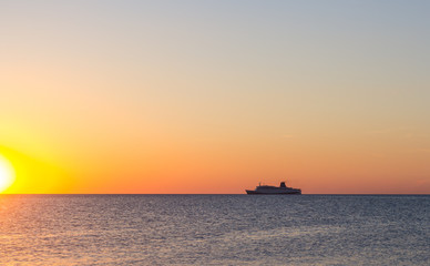 Cruise ship sailing in the sea at sunset 