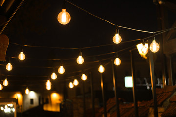 Decoration of the cafeteria. Edison incandescent lamps. Street decor Light lanterns Warm light at night. The web is in the middle of the light bulb. Macro shooting bulbs.