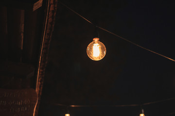 Decoration of the cafeteria. Edison incandescent lamps. Street decor Light lanterns Warm light at night. The web is in the middle of the light bulb. Macro shooting bulbs.