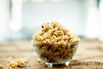 Close up of popular Indian & Asian sweet dish i.e. Malida or churma na ladu or moti chur na ladu in a bowl on brown surface.