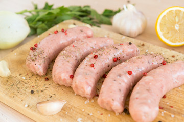 raw sausages, pork sausages on a cutting Board, garlic, lemon, spices,