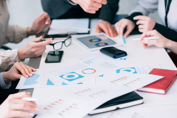 Business analysis and paperwork. Teamwork discussing charts and graphs.