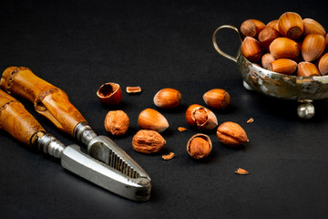 huzelnuts in silver bowl on a table and nutcracker
