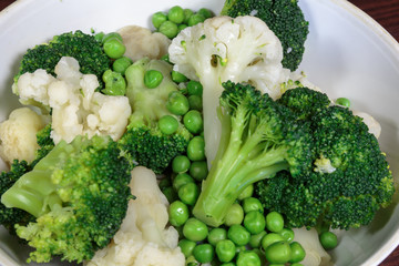Steamed cauliflower, broccoli and green peas as concept of vegan cuisine. Healthy food lifestyle concept.