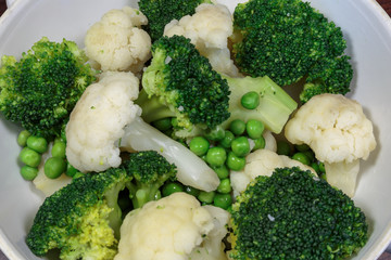 Steamed cauliflower, broccoli and green peas as concept of vegan cuisine. Healthy food lifestyle concept.