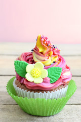 Colorful cupcake with vanilla cream and sugar flowers. Close-up. Free space for your text