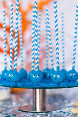 Blue cake pops funny octopuses shared on the glass round plate. Summer candy bar on the party, birthday
