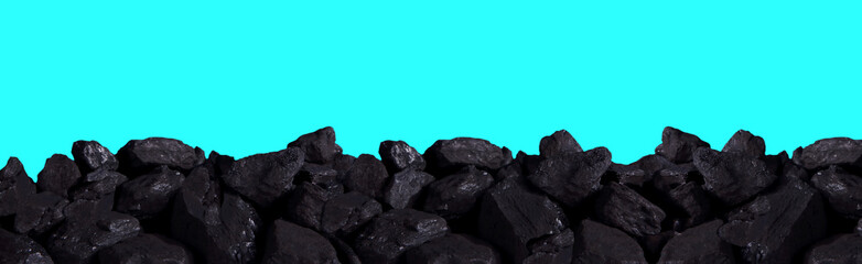 A pile of black coal on an isolated background of blue sky.