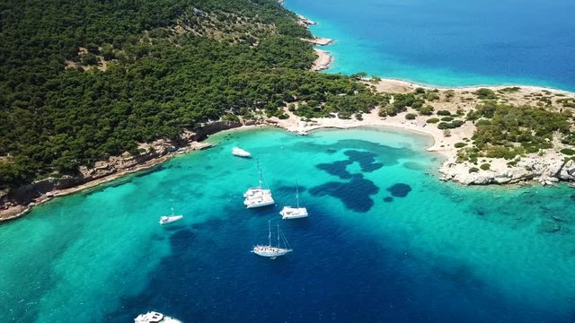Aerial drone bird's eye view video of boat docked in paradise island of Moni next to Aegina island with emerald crystal clear waters, Saronic gulf, Greece