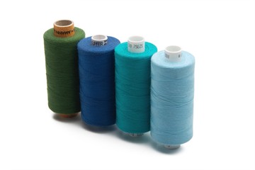 Rainbow colored sewing thread lined in a row