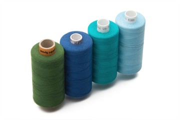 Rainbow colored sewing thread lined in a row