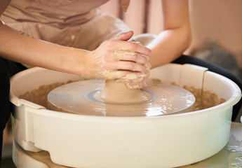 Obraz na płótnie Canvas Woman making ceramic pottery on wheel, creation of ceramic ware. Concept of women's work, craft