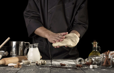 Cook in dark jacket preparing delicious yeast dough for bread