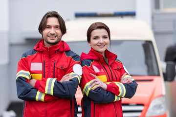 Fototapeta na wymiar Smiling paramedics in uniform standing with crossed arms