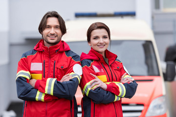 Smiling paramedics in uniform standing with crossed arms © LIGHTFIELD STUDIOS