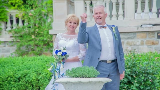 A middle-aged couple is taking photos on their wedding day. They look beautiful.