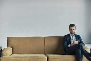 Stylish young man in a suit and bow tie. Business style. Fashionable image. Evening dress. Sexy man standing and looking at the camera.