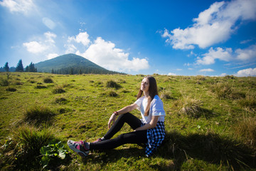 Young happy woman on top of hill enjoy beautiful view of sky and mountains, freedom concept