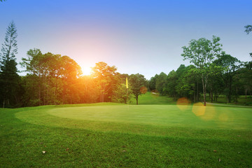 The evening golf course has sunlight shining down at golf course in Thailand