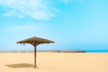 Thatched Parasol on an empty Gold Beach. Al Mamzar, Dubai, Emirates, Jul.2018