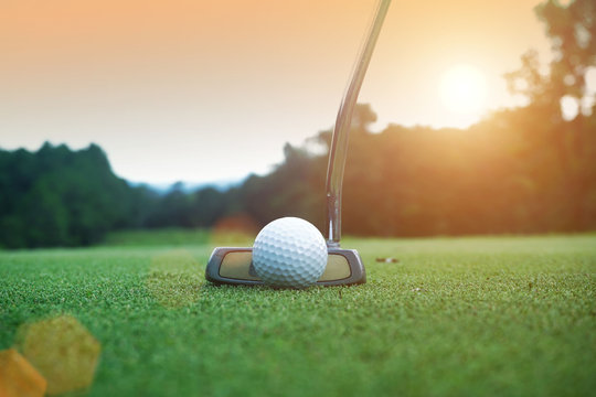 golf club and golf ball close up in grass field with sunset. Golf ball close up in golf coures at Thailand