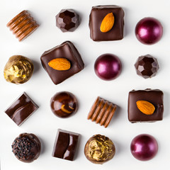 Different homemade chocolate candys on the white background, top view, close up, nobody