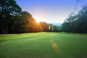 The evening golf course has sunlight shining down at golf course in Thailand