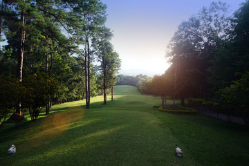 The evening golf course has sunlight shining down at golf course in Thailand
