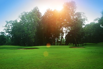 The evening golf course has sunlight shining down at golf course in Thailand